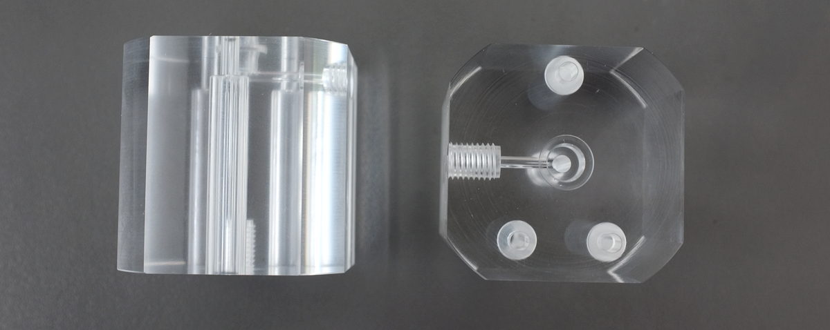 Clear acrylic machined parts before and after polishing on a dark inspection surface